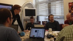 Journalists and student game developers huddled around.