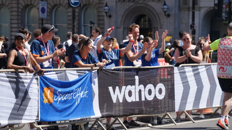 Special Effect team cheering the runners on from behind the barriers near the finishing line.