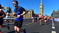 A picture of me (Luc Shelton) in a SpecialEffect athletic jersey running across London Bridge. Behind me is the Palace of Westminster and Big Ben.