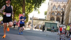 A picture of myself (Luc Shelton) running past the Palace of Westminster. There is someone to my left. I am wearing a SpecialEffect athletic jersey.